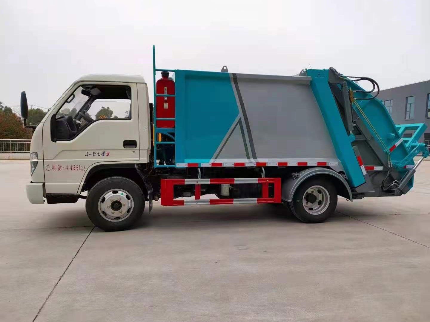 Front side view of Foton Forland mini compactor garbage truck